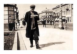 Рабочий, читающий газету с манифестом об учреждении Государственной думы. Фотография. 6 авг. 1905 г. 